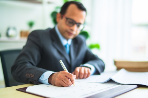 man achter bureau plant afspraak voor examen