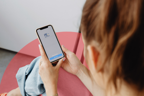 Vrouw met mobiele telefoon met PE-online app