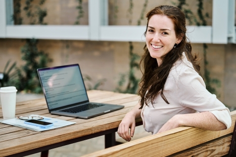 Jonge vrouw achter laptop maakt self-assessment