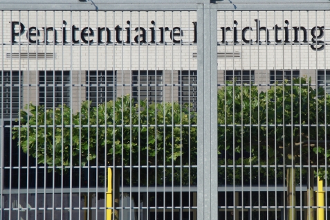 Hek met daarachter een gevangenis (Penitentiaire inrichting)