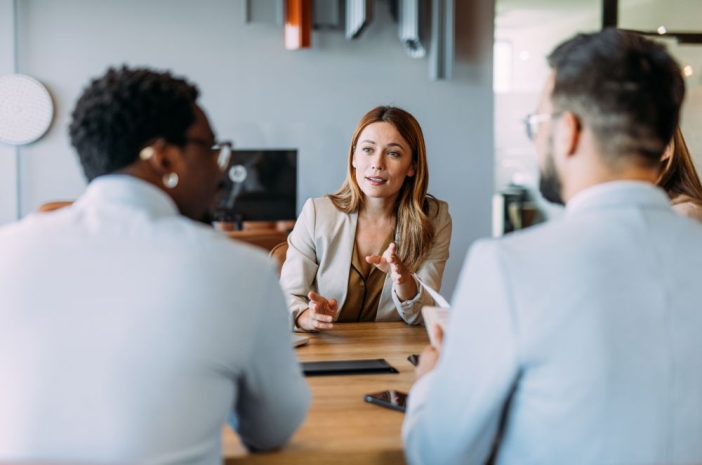 Jonge vrouw in gesprek met twee personen
