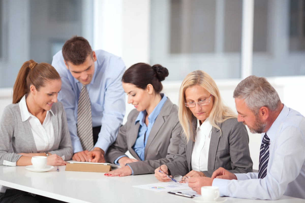 Collega's aan een vergadertafel die elkaars werk toetsen