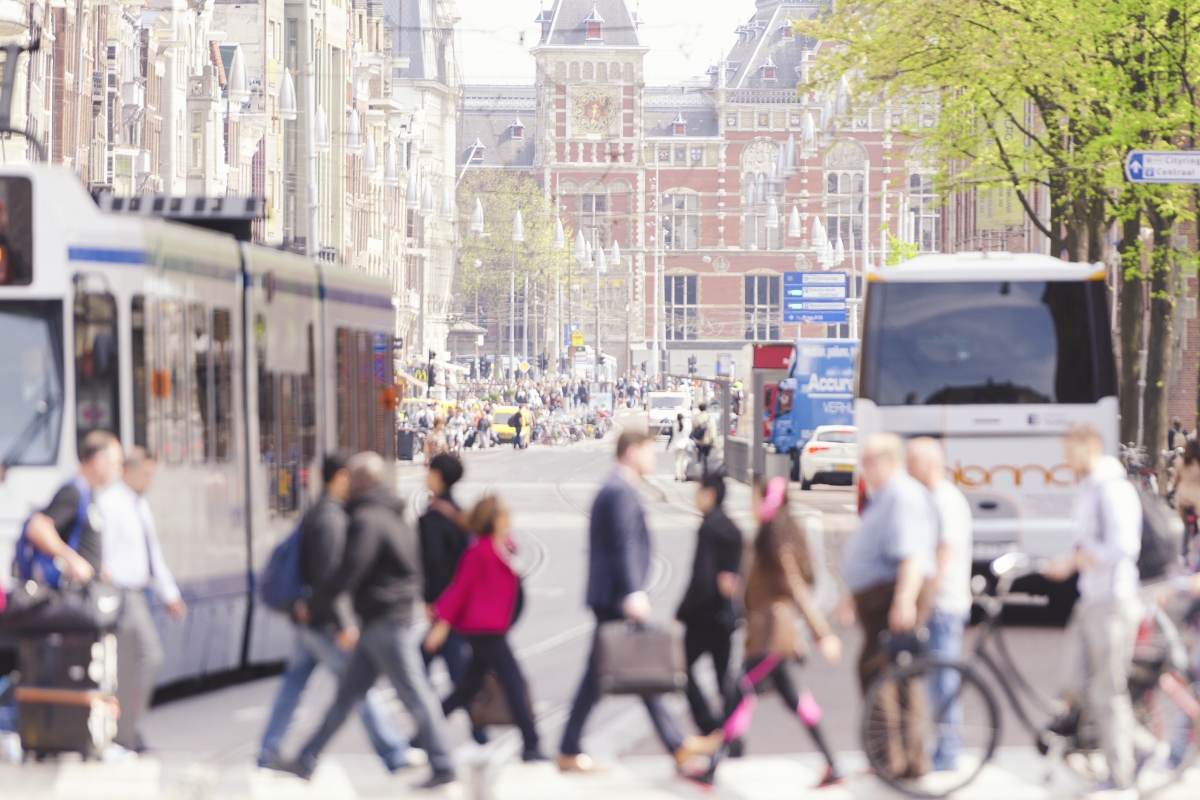 Mensen op straat in Amsterdam met tram