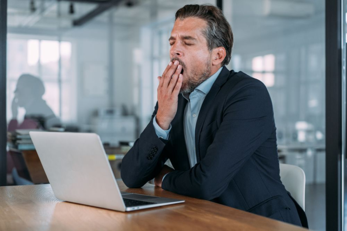 Gapende man achter laptop