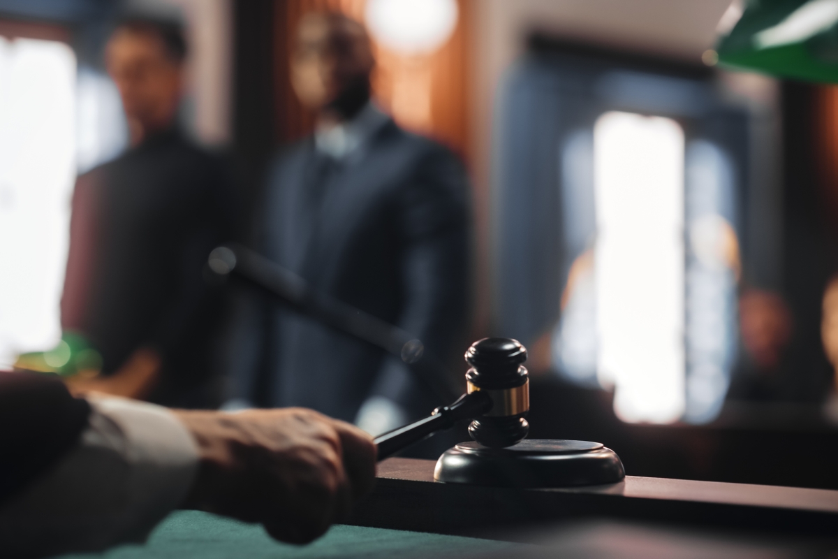 Hand rechter slaat met hamer op blok, in de achtergrond verdacht met advocaatock-1346156698