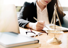 Vrouw in pak met laptop, aantekeningenblok en weegschaal