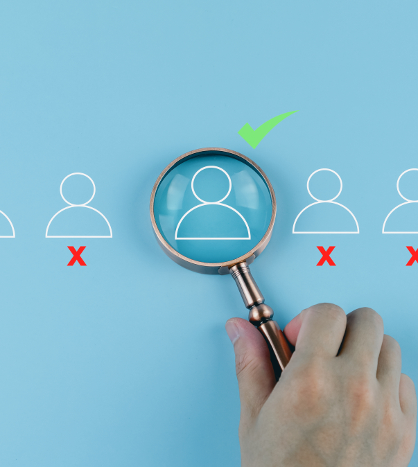 Poppetjes op een rij waarvan 1 met een groen vinkje onder een vergrootglas.