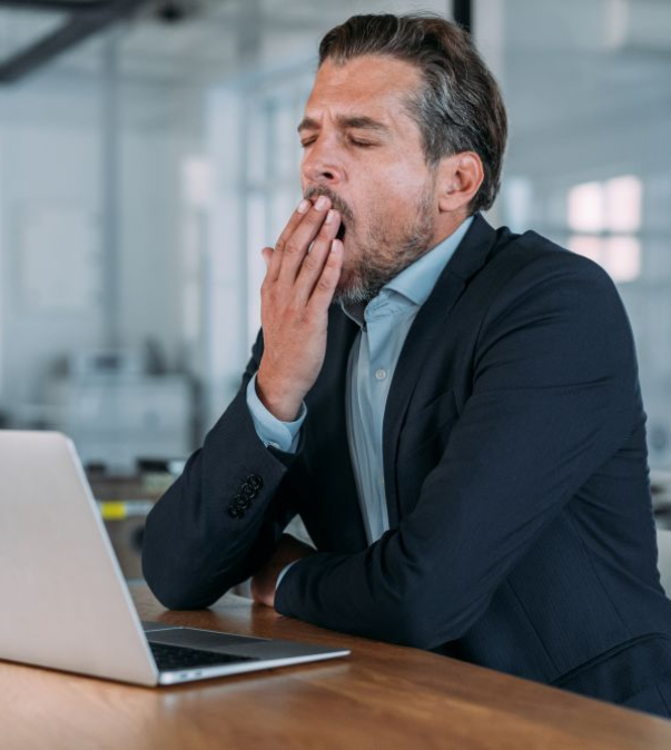 Gapende man achter laptop