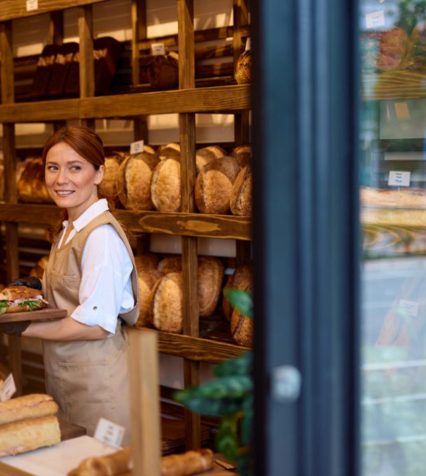Verkoopster in bakkerij met brood vast