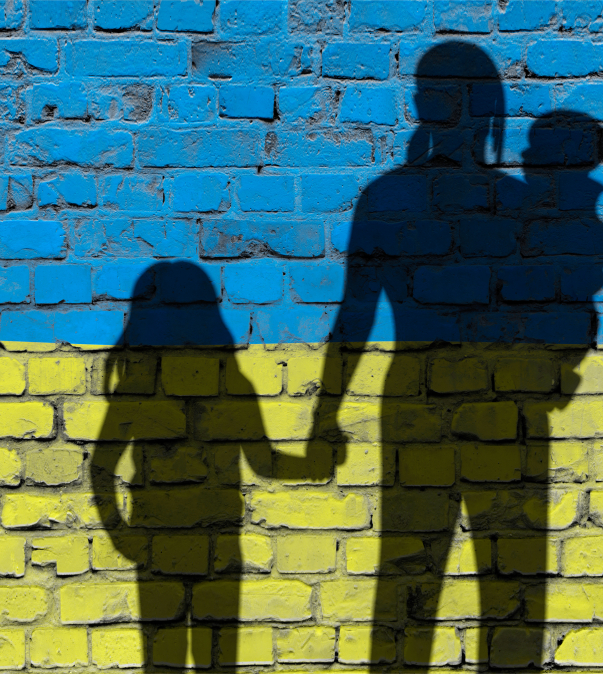 Muur in kleuren vlag Oekraine met schaduw van vluchtelingen (moeder, kinderen)