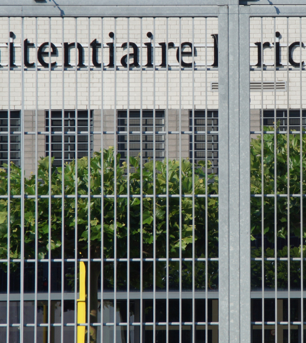 Hek met daarachter een gevangenis (Penitentiaire inrichting)